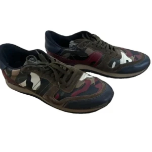 Valentino Rockrunner sneakers camo - Snygga Valentino Rockrunner sneakers med camouflage-mönster i grönt, brunt, svart, vinrött och beige. Skorna har snörning och detaljer i mocka och skinn, samt en platt sula. Perfekta för dig som vill sticka ut med exklusiva sneakers.