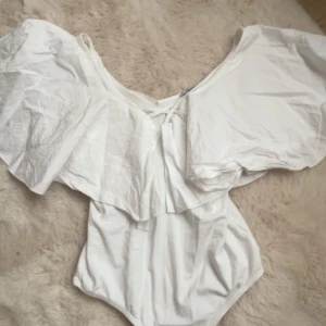 Vit offshoulder topp med volang - Super fin vit volang body från Zara, använd fåtal gånger, bara att fråga om ni har frågor💗