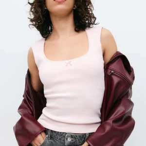 Ljusrosa ribbad linnetopp med rosett från Gina Tricot - Supersöt ljusrosa linnetopp med ribbad struktur och liten rosett framtill. Toppen har breda axelband och en rundad urringning med diskret spetskant. I toppen skick, storlek S ✨🌸