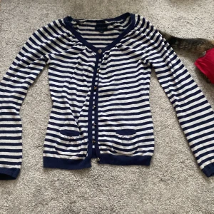 Randig kofta - Blå och vit randig kofta, men små fickor på framsidan. Märket är Tommy Hilfiger.