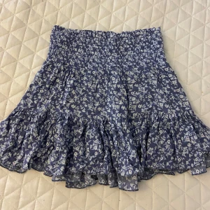 Blommig blå volangkjol från lager 157 - Superfin kort kjol från lager 157 i blått med vitt blommönster. Pris går att diskutera💕