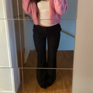Kostymbyxor  - Säljer ett par mörkblå bootcut-byxor från Gina Tricot med vita tunna ränder. Byxorna har hög midja och en snygg, figurnära passform upptill som går ut i vida ben. Perfekta för dig som gillar en trendig och stilren look. PRIS KAN DISKUTERAS 