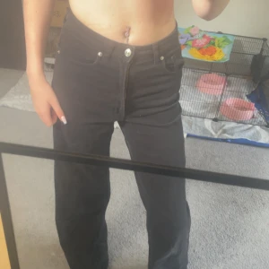 Svarta jeans från Divided, strl 38 - Svarta jeans från Divided i storlek 38. Klassisk femficksmodell med raka ben och hög midja. Jeansen är i bomull och har dragkedja och knapp framtill. Perfekta till sneakers eller boots för en chill look.