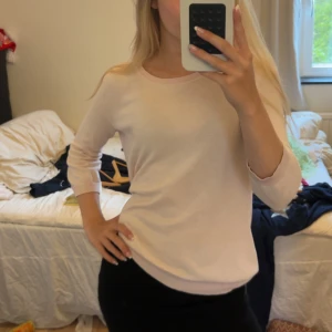 Ljusrosa stickad trekvartsärmad tröja - Supersöt ljusrosa stickad tröja från Peter Hahn med rund halsringning och långa ärmar. Enkel och clean design som är lätt att matcha till olika outfits. Perfekt för dig som gillar en stilren och feminin look.