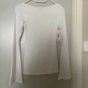 Vit långärmad topp från Nelly - vit långärmad topp från Nelly, den är endast testad men den satt nt som ja ville så därför säljer ja den!!