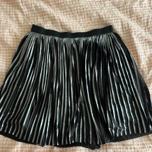 Silvrig och Svart kjol  - Säljer denna så söta silvriga och svarta kjol. Den har även en svart underkjol (se sista bilden). Märket är Name It och storleken är 14y men jag skulle säga att den passar både S och M. Säljer direkt för 140kr! 