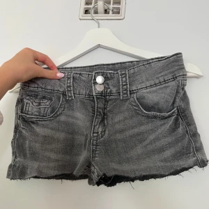Grå jeansshorts från Gina Tricot - Snygga grå jeansshorts från Gina Tricot som jag sytt om från jeans till short. Shortsen har dubbla knappar i midja. 