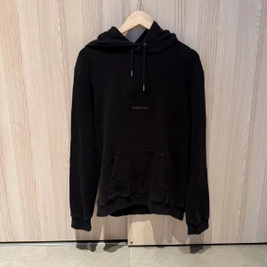 Saint Laurent Hoodie Svart - Svart hoodie från Saint Laurent i storlek L men sitter som en M. Perfekt för en chill och avslappnad stil.