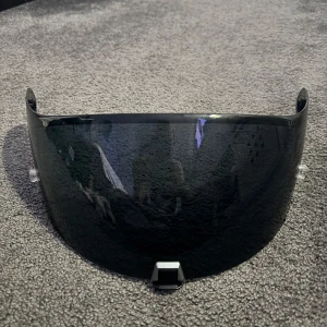 Mörkblå visirglas till hjälm - Köpt från AliExpress men passar inte min hjälm. Osäker vilket hjälm märke den passar. Helt ny. Passar inte LS2 iallafall. Köptes för 100kr