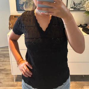 Svart stickad topp  - Snygg svart stickad topp med v-ringad hals och vågig kant. Knappt använd så i superbra skick. 