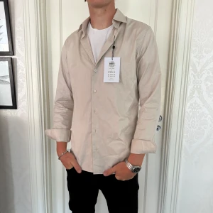 Selected home helt ny  - Selected homme skjorta, helt ny, färg beige, storlek M, nypris 599, modellen är 188 och väger 75kg 