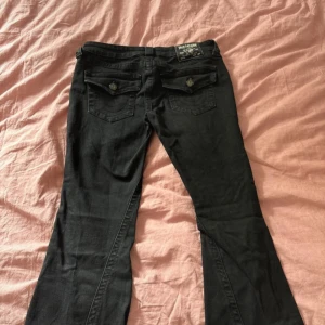 Svarta bootcut jeansbyxor - Fina true religion jeans i modellen joey.     Kommer tyvärr inte till användning. Low waist :) Priset är inte diskuterbart 