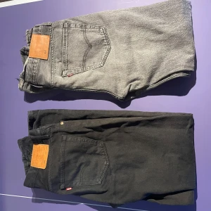 Två Levi's 501 jeans säljes ihop. - Två par Levi's 501 jeans, ett par i svart och ett par i grått. Båda är straight-leg och är av storleken 32/34. !!Säljes endast tillsammans!!