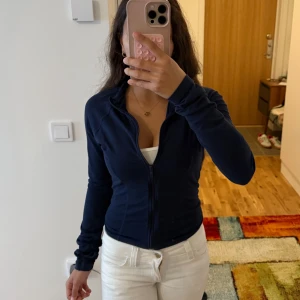 Gina Tricot soft touch zip jacket - Snygg mörkblå kofta från Gina tricot i slim fit med hel dragkedja framtill och hög krage. Jackan har långa ärmar och en sportig, figurnära passform som passar perfekt till vardagslooken. Knappt använd! Kan mötas eller skickas💌