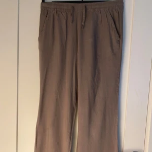 Beiga linnebyxor med snörning - Snygga beiga linnebyxor med avslappnad passform och elastisk midja med snörning. Byxorna har raka ben, sidfickor fram och en bakficka. Perfekta för en chill och stilren look🤎🤎🤎