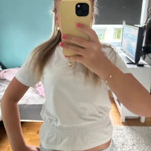 Vit kortärmad topp med resår -  Jättefin vit topp som tidigare köpt Second hand men jag har inte kommit till användning. Fint skick och inga fläckar synliga. Snabb frakt och pris kan diskuteras.🥰😇🩷🧡❤️💛
