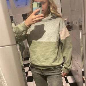 Hoodie - Snygg hoodie från H&M med colorblock-design i ljusgrönt, grått och en touch av ljusrosa på axlarna. Tröjan har huva, långa ärmar och en relaxed fit. Perfekt för chill dagar eller när du vill ha en casual vibe. Skriv till mig om ni har frågor 