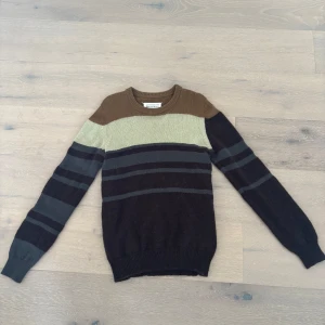 Maison Margiela Tröja - Stickad tröja från Maison Margiela – storlek S Elegant och unik tröja från Maison Margiela, perfekt för höst och vinter. Sitter true to size och passar dig som är ca 176–183 cm lång, beroende på kroppsform. Jag är själv 180 cm och väger 74 kg – tröjan sitter utmärkt.  Tröjan är i fint skick och erbjuder både stil och komfort till vardagen. Fler bilder kan skickas vid intresse. Pris kan diskuteras vid snabb affär.