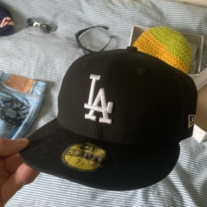 Svart LA 59FIFTY keps från New Era - svart 59FIFTY keps från New Era med LA-logga broderad i vitt framtill och MLB-logga bak. 