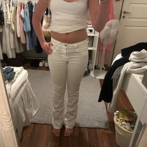 Vita bootcut jeans - Säljer ett par vita jeans med bootcut-modell och låg/ mid midja. Jeansen har varit skinny men är omsydda till bootcut men inget som syns🥰Säljer då de är lite små till mig😔