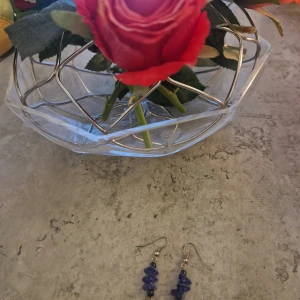 Blå örhängen med stenar - Säljer ett par snygga örhängen med blå oregelbundna stenar på rad. De har krokar i silverfärg och ger en cool och unik vibe till din stil. Perfekta för dig som gillar smycken som sticker ut lite extra.