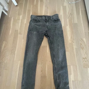 Grå Levi's 501 jeans, straight fit - Säljer ett par grå Levi's 501 jeans i klassisk straight fit. Jeansen har fem fickor, knappgylf och den ikoniska röda Levi's-taggen bak. Perfekt tvättad grå färg som ger en cool vintage vibe. Passar dig som gillar tidlös stil och raka ben.