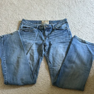 Blå bootcut jeans  - Snygga ljusblå jeans från amerikan rag cie med bootcut passform. Jeansen har klassisk femficksdesign, diskret slitning och broderad logga på bakfickan. Tillverkade i mjukt bomullstyg med dragkedja och knapp framtill.