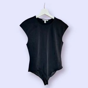 Svart body i storlek L från H&M - Svart ärmlös body med rund halsringning. Aldrig använd.