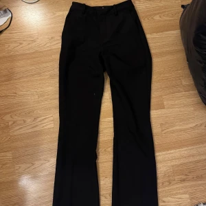 Svarta kostymbyxor bik bok -  svarta kostymbyxor med bootcut passform. Jättebra skick nästan oanvända. Storlek 34