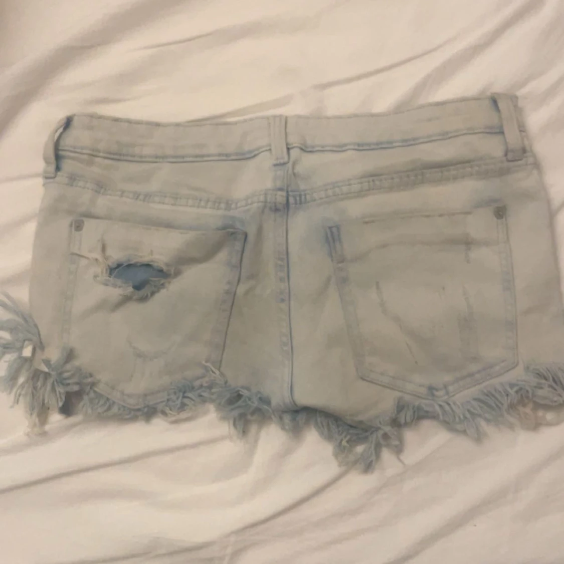 Ljusblå slitna jeansshorts med fransar - 1
