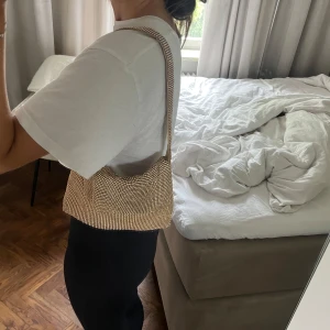 Guldig axelväska Bianca x Nelly - Den har ett litet hål på insidan men annars i bra skick!