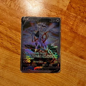 Arceus V - Coolt Arceus V-kort från Pokémon! Perfekt för dig som samlar eller spelar Pokémon TCG. Det är lite repor och sånt.