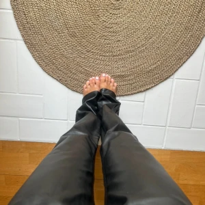 Svarta skinnbyxor från BikBok - Snygga svarta byxor i skinnimitation från BikBok. De har raka ben, klassisk femficksmodell. Perfekta för att lyfta vilken outfit. Stängs med knapp och dragkedja framtill.