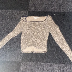 Leopardmönstrad långärmad topp H&M - Säljer en snygg långärmad topp från H&M med leopardmönster i beige och bruna toner. Tröjan har en tight passform och är tillverkad i ett mjukt, stretchigt material. Säljer för att den är för liten.