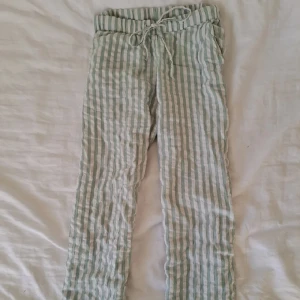 Randiga pyjamasbyxor - Snygga och bekväma pyjamasbyxor, de har raka, luftiga ben och en söt mintgrön färg i ränderna samt vit. De har fickor och är i jättebra skick! Nypris 399 kr