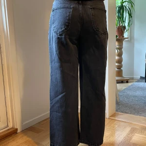 Svarta vida jeans - Svarta jeans från Boohoo i storlek 34. De är raka, har mellanhög/hög midja och så fina, vida ben! Bekväma och sparsamt använda. Färgen syns bäst på de tre sista bilderna.