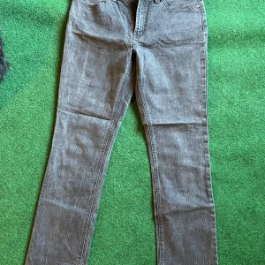 Grå jeansbyxor från Kapp Ahl - Snygga grå jeansbyxor från Kapp Ahl i rak modell. Byxorna har klassisk femficksdesign och är tillverkade i ett mjukt jeanstyg som passar perfekt till en avslappnad stil. Perfekta att matcha med sneakers eller boots.