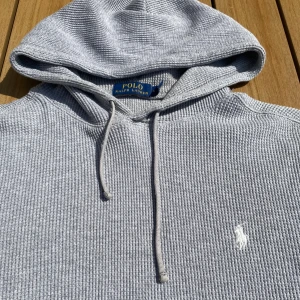 Grå hoodie från Polo Ralph Lauren - Säljer en grå hoodie från Polo Ralph Lauren med klassisk huva och snörning. Tröjan är i unikt material och har en liten defekt som inte syns om man inte kollar noga. Materialet är mycket utstrechat vid ärmsluten och i midjemudden. Är lite liten i storleken. Vid frågor eller funderingar skicka ett meddelande💫