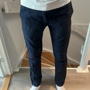 Mörkblå linnebyxor från Ralph Lauren - Snygga mörkblå linnebyxor från Polo Ralph Lauren i slim fit-modell. Byxorna har slim fit passform, bälteshällor och knäppning fram. Tillverkade i linne, perfekta för en clean och stilren look. Storlek W30 L32.