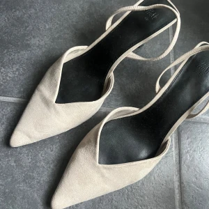 Beige pumps med spetsig tå från H&M - Super snygga slingbacks från hm som inte kommer till användning. Dom är i super bra skick och knappt använda. Super snygga till klänning, kjol eller jeans! 😍😍