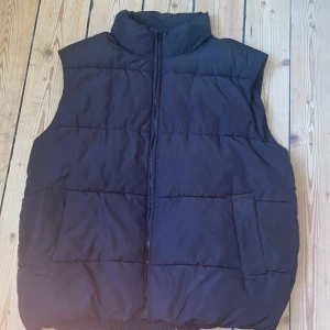 Svart dunväst från Monki, storlek L - Svart quiltad dunväst från Monki i storlek L. Inga större skador. Om du undrar något så säg bara till!