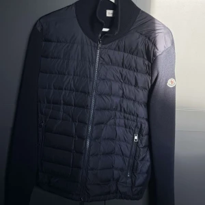 Marinblå Moncler cardigan  - Snygg marinblå cardigan från Moncler. Perfekt för dig som vill ha en stilren och exklusiv look under höst och vinter. Varan har inga defekter alls, och ser så gott som ny ut. Pris kan diskuteras!!