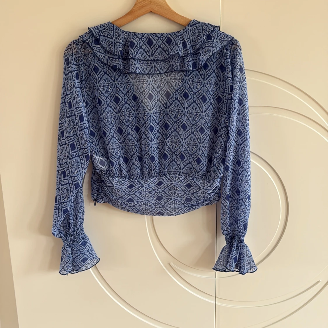 Blå mönstrad blus med volang - 1