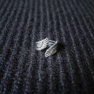 Ailes d'Ange - Angel Wings - Justerbar ring i stainless steel, rost- och nickelfri. Två stiliserade vingar möts i en svepande form - distinkt detalj med elegans och närvaro.