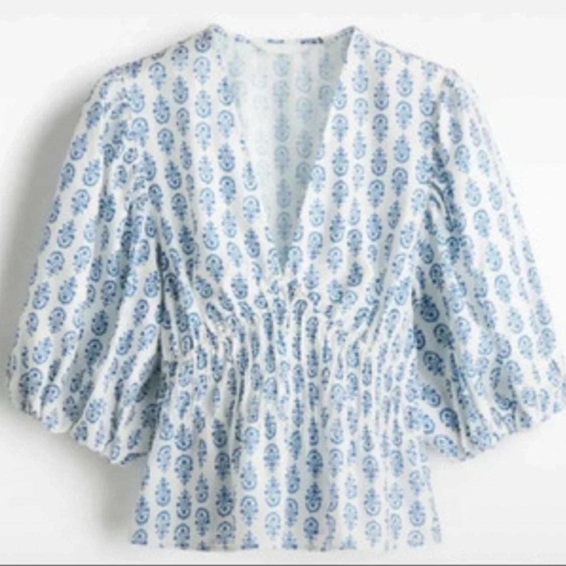 Vit och blå blus med v-ringning