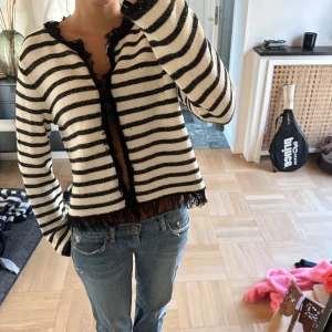 Randig kofta med fransiga kanter - Så snygg svartvit randig kofta med fransiga detaljer längs kanterna.🦓de är hooks så de är inte knappar men kan knäppas igen🤍