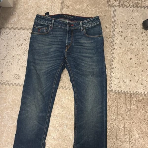 Handpicked blå jeans med orange detaljer - Stilrena Jeans från Handpicked i perfekt skick. De är endast använda under ett tillfälle. Såklart äkta nypris ligger på ungefär 3000kr men säljs för endast 750 då jag måste få bort dem fort. Fler bilder kan såklart lösas