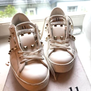 Vita Valentino 37 - Säljer vidare ett par Valentino jag köpt här men det råkade bli fel storlek. De är i fint skick med guldiga nitar, perkekt till sommaren! 