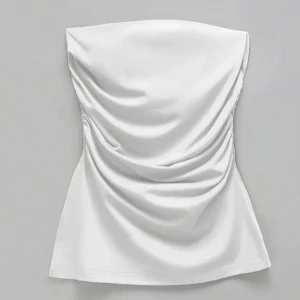 Vit tubtopp  - Säljer en vit tubtopp med snygga rynkade detaljer på sidorna. Toppen är axelbandslös och har en stilren, enkel design som passar perfekt till många olika outfits.