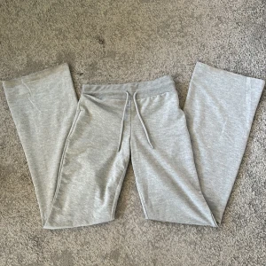 Grå yogabyxor från lager 157 - Säljer ett par ljusgrå yogabyxor med resår och dragsko i midjan. De är utsvängda, ganska tajta upptill och är tillverkade i mjukt material. Har inte använts någon gång. Midwaist men kan vikas ner en gång och bli lowwaist. Skriv privat om du har frågor!